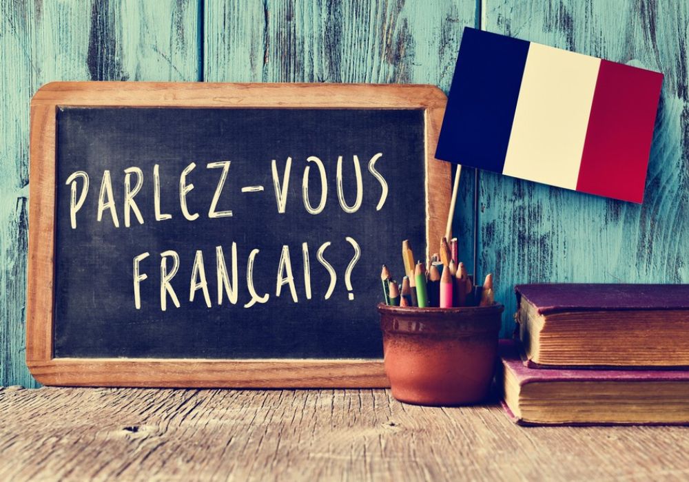 Das Bild zeigt eine Tafel auf der "Parlez-vous Français" steht.
