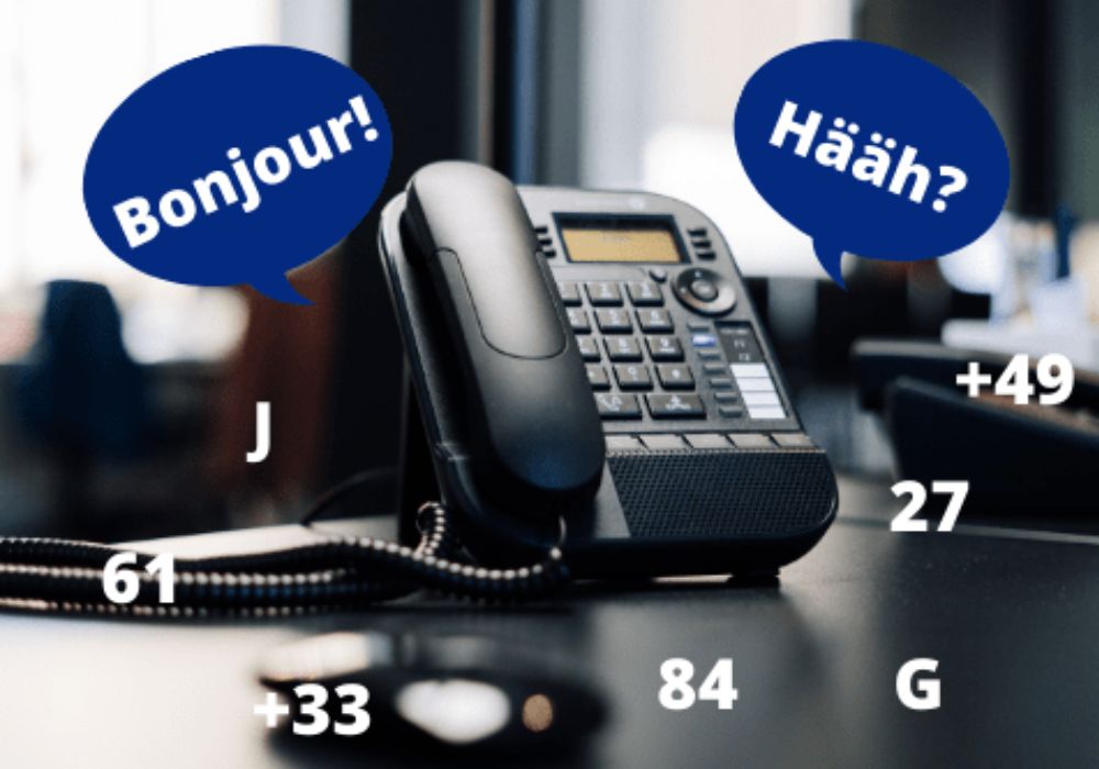 Das Bild zeigt ein Telefon mit Sprechblasen die "Bonjour" und "Hääh?" zeigen, was eine Schwierigkeit beim Telefonieren mit Franzosen zeigt.