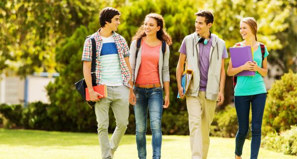 Das Foto zeigt eine Gruppe junger Erwachsener, welche über den Hof ihrer Universität laufen.